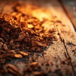A close up shot of loose pipe tobacco scattered on an aged wooden desk, the rich brown tones of the tobacco